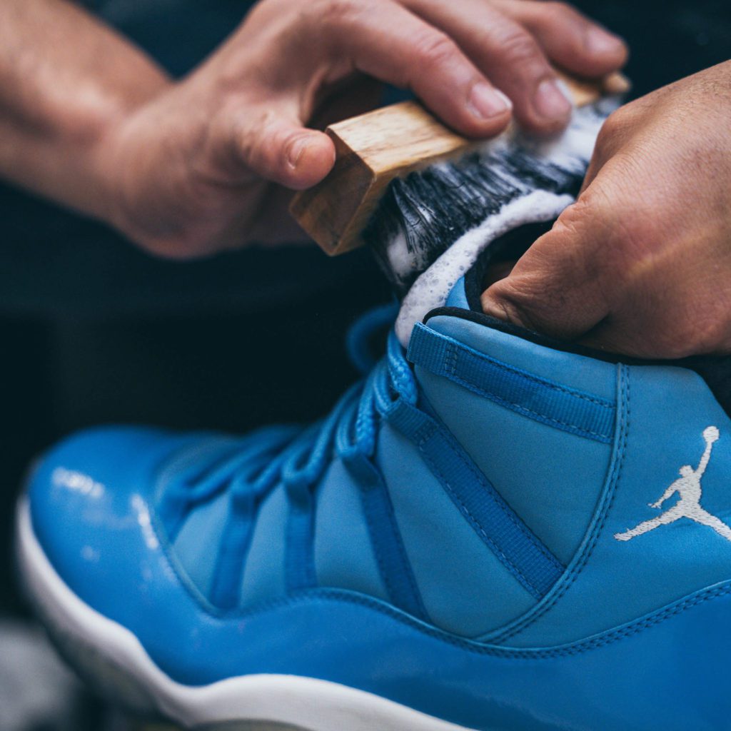 Man cleans blue Jordans with Shoe MGK