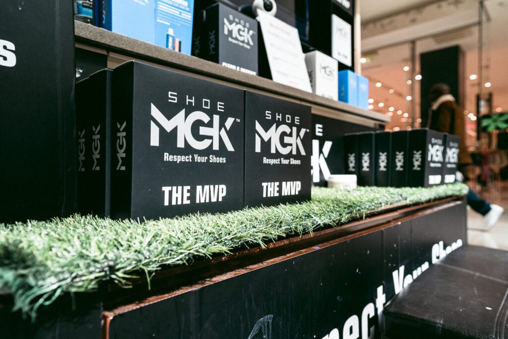 The Shoe MGK MVP Kit XL lined up on a shelf at a mall kiosk