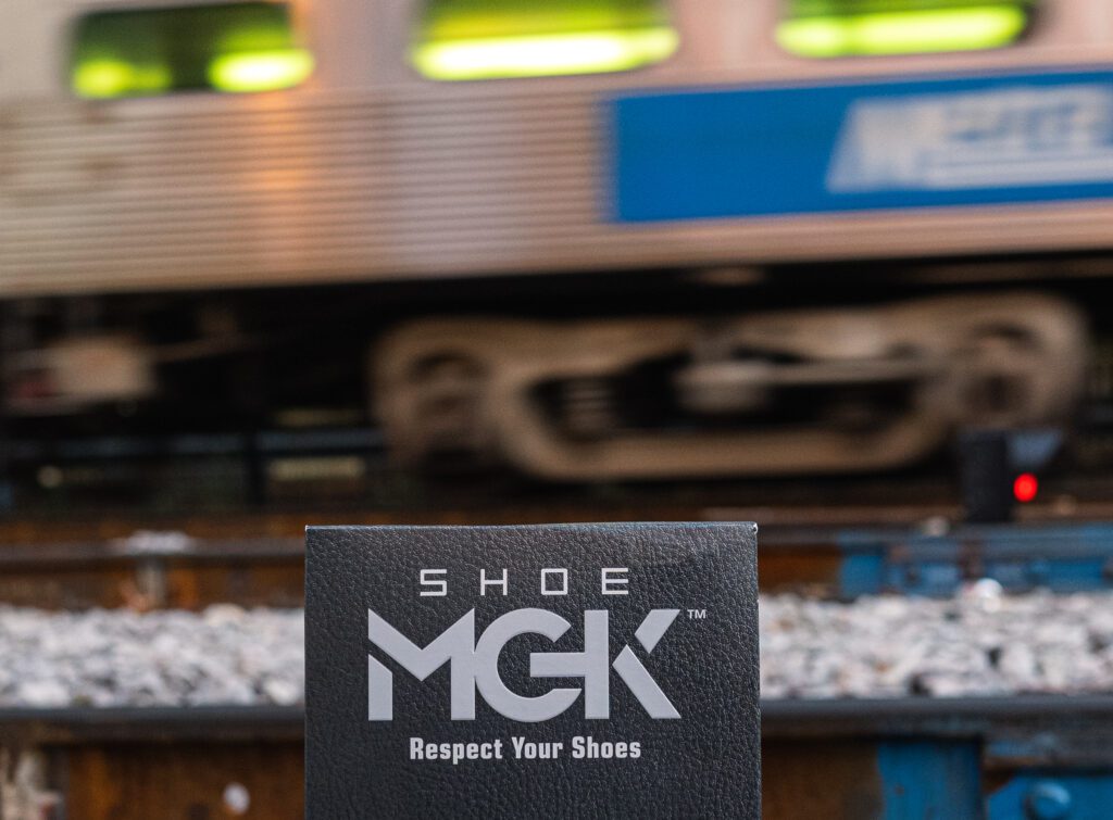 The Shoe MGK Leather Care Kit in front of a moving train