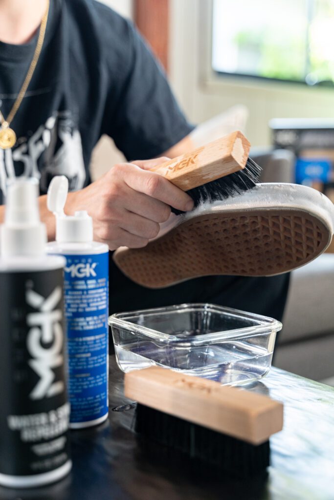 Man scrubs a shoe with a nylon shoe brush