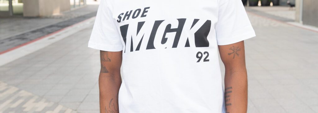 Man wears a white Shoe MGK T-shirt