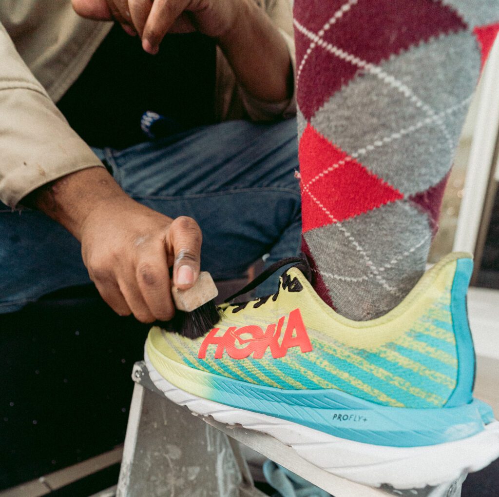 Man cleans colorful Hoka sneakers with Shoe MGK