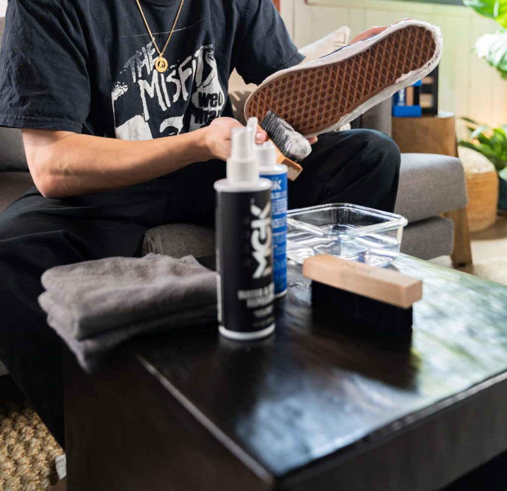 Man cleans shoes with Shoe MGK Clean and Protect kit