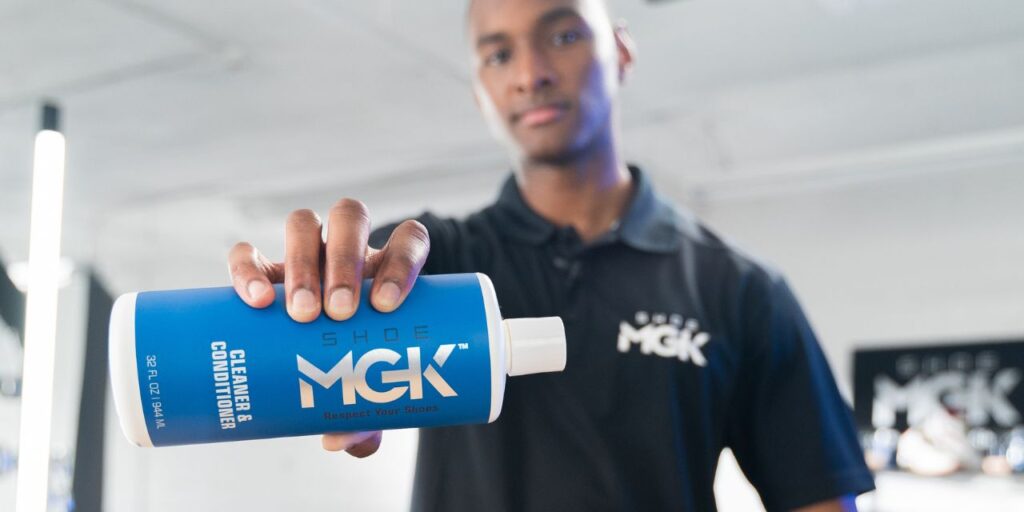 Man holding a bottle of the Shoe MGK Cleaner and Conditioner
