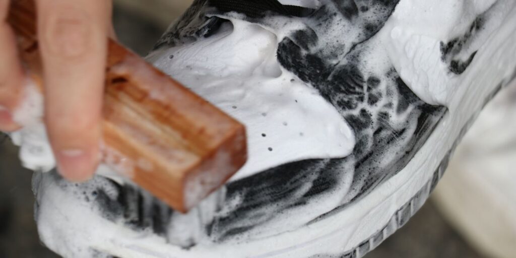 Man scrubs Nike Dunks with Shoe MGK Cleaner and Conditioner
