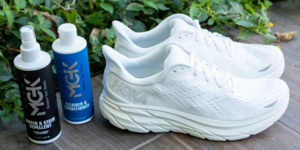 The Shoe MGK Cleaner and Conditioner and the Shoe MGK Water and Stain Repellent next to Hoka running shoes