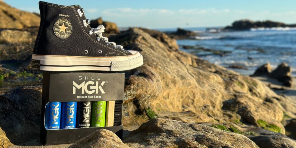 Converse high tops standing on the box of the Shoe MGK Complete Kit at the beach
