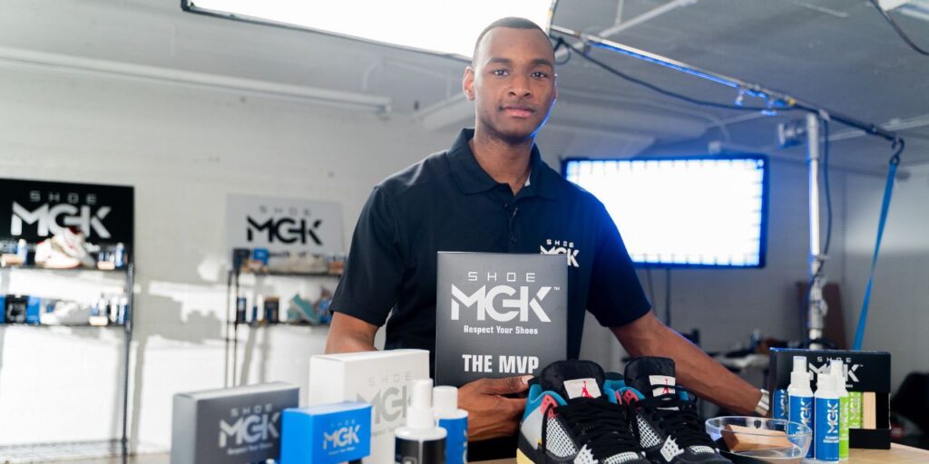 Man holding a box of the Shoe MGK MVP Kit with shoes and product infront of him