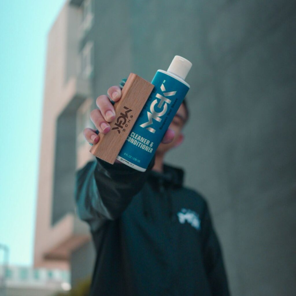 Man holds Shoe MGK Cleaner and Conditioner