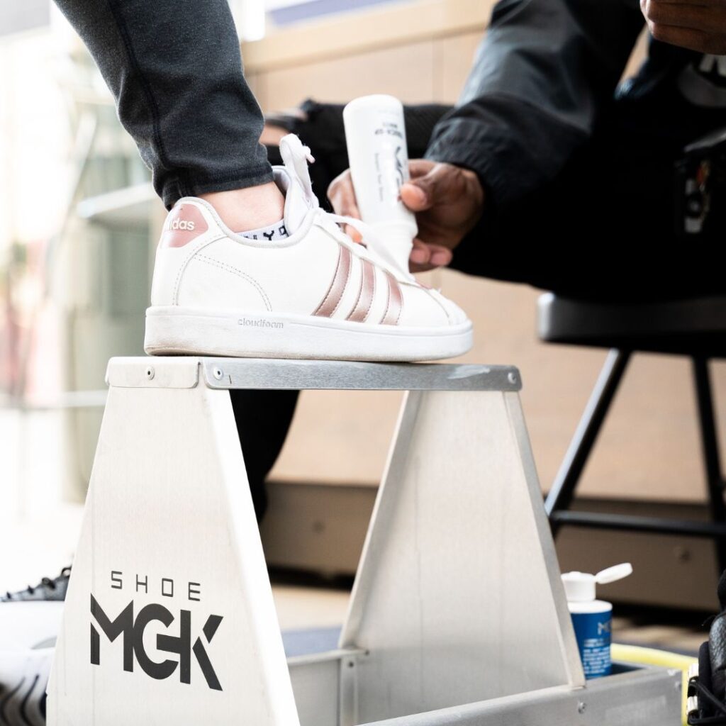 Man applies the Shoe MGK White Touch-Up to a pair of white shoes