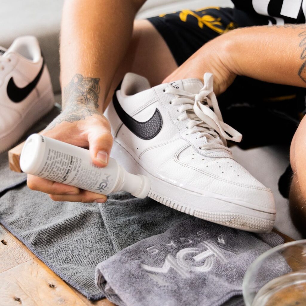 Man cleans white shoes with the Shoe MGK White Touch Up