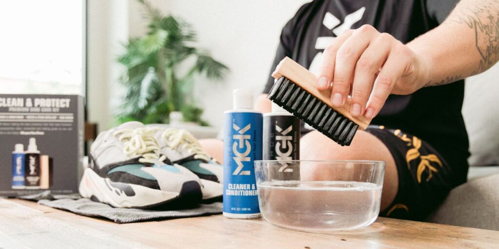 Man dips shoe brush into a bowl of water