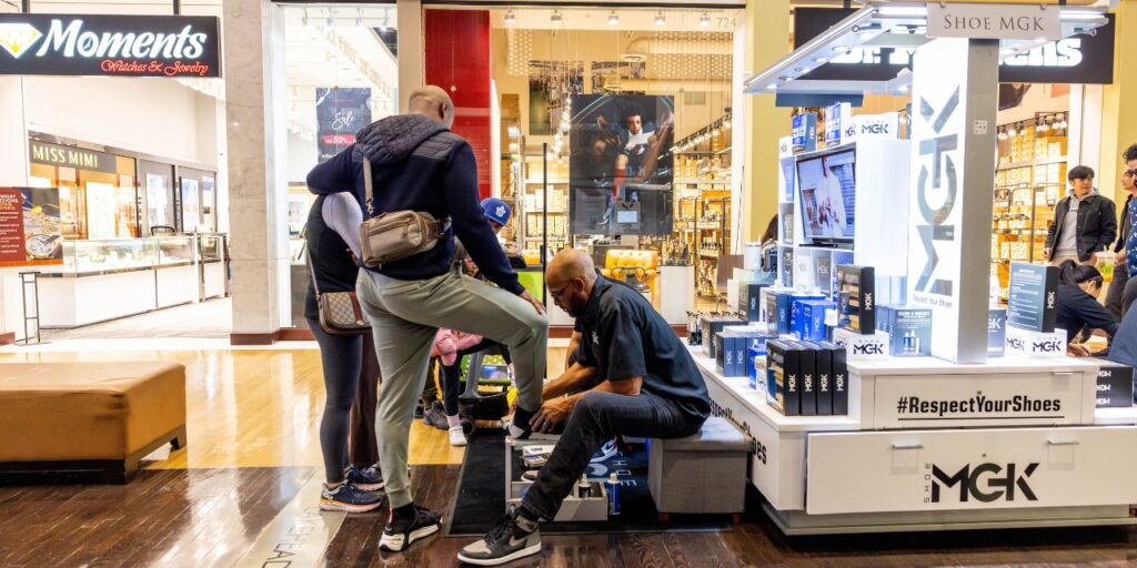 Man cleans shoes at a mall kiosk for Christmas