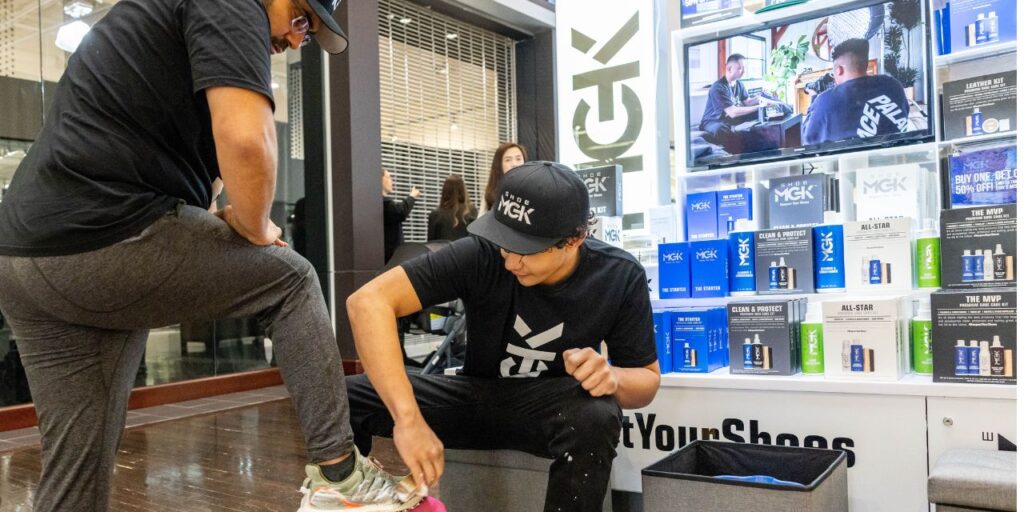 Man cleans shoes at a mall kiosk in Canada