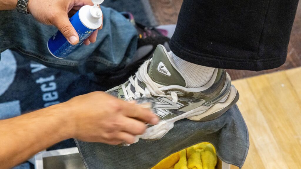 Man cleans shoes with the Shoe MGK Cleaner and Conditioner