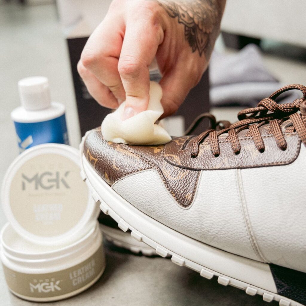 Man applies shoe mgk leather cream onto leather shoes