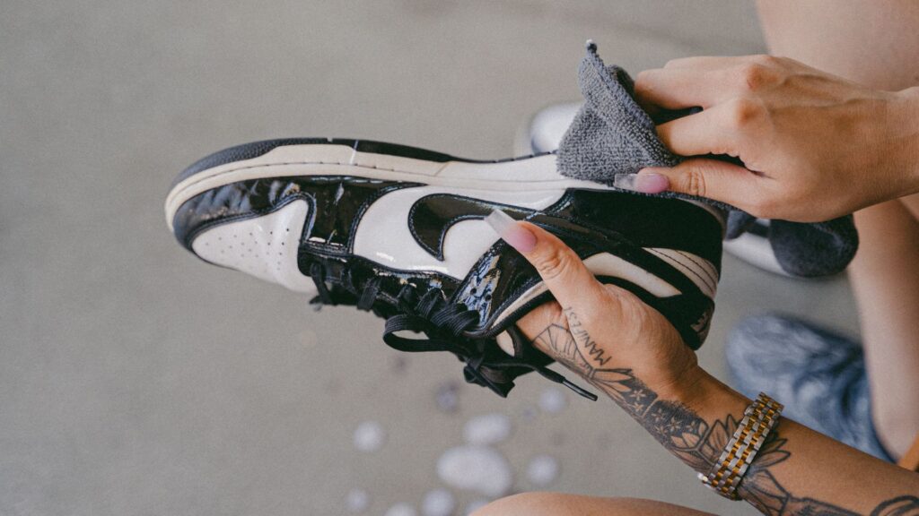 Woman cleans a pair of white sneakers