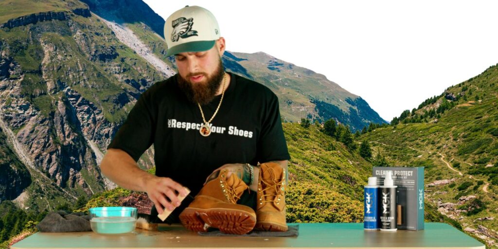 Man cleans hiking boots on a hiking trail