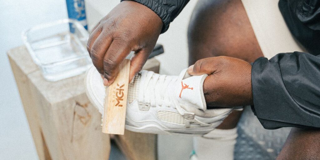 Man cleans white shoes with Shoe MGK